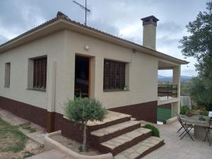 ein kleines Haus mit einem Tisch und einer Terrasse in der Unterkunft Hotel Balfagón in Calanda