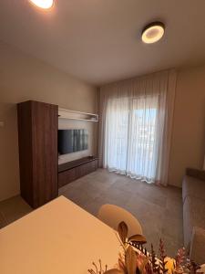 a living room with a couch and a television and a table at Dimora Nòva Verona in Verona