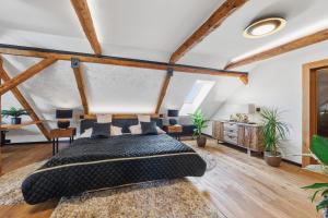 a bedroom with a large bed in a room with wooden ceilings at Apartmány Wake up Coffee in Proseč