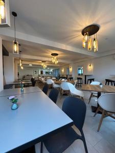 a dining room with tables and chairs and lights at Pótkerék Motel in Győr