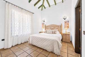 a white bedroom with a bed and a window at CERCADO DEL MEDIO, CHALET con PISCINA PRIVADA in Adeje +20 photos