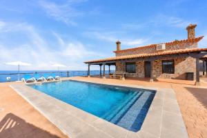 a villa with a swimming pool next to the ocean at CERCADO DEL MEDIO, CHALET con PISCINA PRIVADA in Adeje