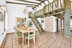 a dining room with a table and a staircase at CERCADO DEL MEDIO, CHALET con PISCINA PRIVADA in Adeje