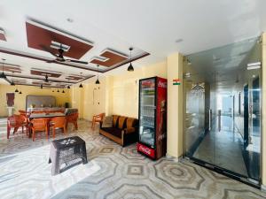 a living room with a coca cola machine and a table at Hotel RL Ramayansh - 300 mtr From Ram Mandir Ayodhya in Ayodhya