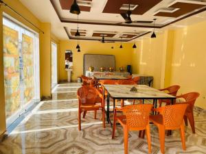 a restaurant with tables and chairs in a room at Hotel RL Ramayansh - 300 mtr From Ram Mandir Ayodhya in Ayodhya