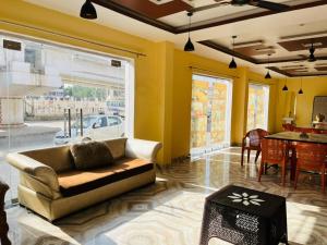 a living room with a couch and a table at Hotel RL Ramayansh - 300 mtr From Ram Mandir Ayodhya in Ayodhya