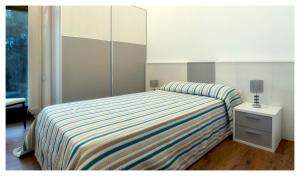 a bedroom with a bed with a striped blanket at Elegant Villa in Outes with Pool in Serantes