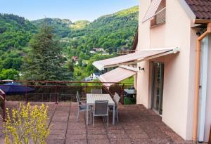 a balcony with a table and chairs and mountains at Appartement confortable à Oderen 68 m² avec piscine partagée in Oderen