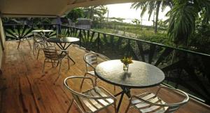 a patio with tables and chairs on a balcony at Charming Villa in Foulpointe with Sea View in Foulpointe