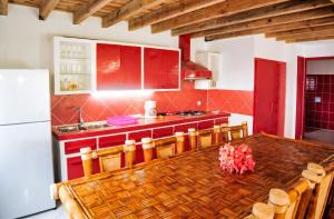 a kitchen with a wooden table and red cabinets at Charming Villa in Foulpointe with Sea View in Foulpointe