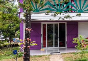 a purple house with a tree in front of it at Charming Villa in Foulpointe with Sea View in Foulpointe