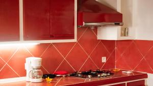 a kitchen with red walls and a counter with a mixer at Charming Villa in Foulpointe with Sea View in Foulpointe