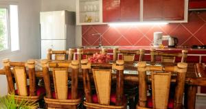 a kitchen with a bunch of wooden chairs in front of a table at Charming Villa in Foulpointe with Sea View in Foulpointe +35 photos