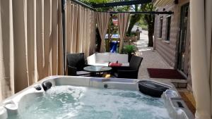 a jacuzzi tub in a patio with a table and chairs at Welcoming Villa in Vantačići with Pool and Sea View in Vantačići