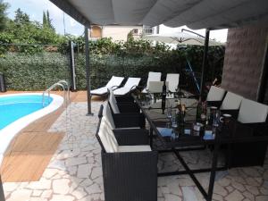 a patio with a table and chairs next to a pool at Welcoming Villa in Vantačići with Pool and Sea View in Vantačići +30 photos