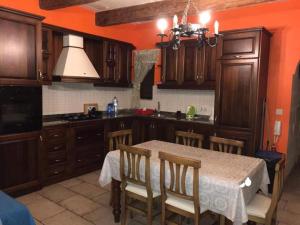 a kitchen with wooden cabinets and a table with chairs at Exceptional villa in In-Nadur with private pool. in Nadur +25 photos