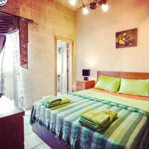 a bedroom with a bed with green pillows on it at Exceptional villa in In-Nadur with private pool. in Nadur