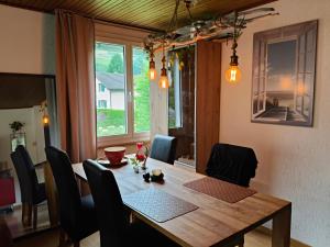 a dining room with a wooden table with chairs and a window at Grosses Doppelzimmer in Privathaus in Flums