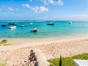 a group of boats in the water on a beach at Charming Apartment in Pamplemousses, 30 m² with Garden View in Pamplemousses Village