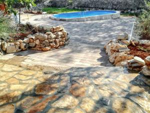 a patio with a rock wall and a swimming pool at Charming Villa in Filozići with Private Pool in Filozići