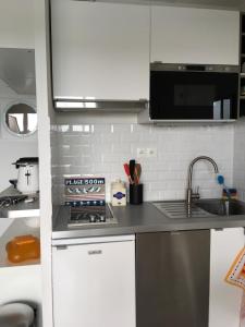a kitchen with a sink and a stove top oven at Appartement cosy avec piscine partagée - Guérande - 30 m² in Guérande