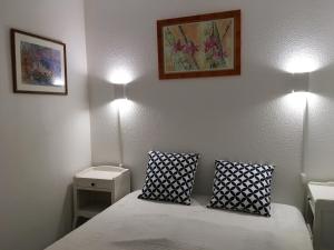 a bedroom with a bed and two lights on the wall at Appartement cosy avec piscine partagée - Guérande - 30 m² in Guérande +16 photos