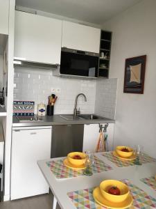 a kitchen with two yellow plates on a table at Appartement cosy avec piscine partagée - Guérande - 30 m² in Guérande