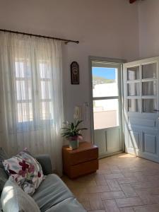 a living room with a couch and a sliding glass door at EnjoyPatmos in Skala
