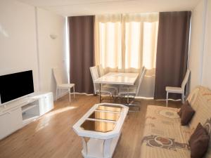 a living room with a table and a tv at Appartement lumineux à Saint-Cyprien 45 m² vue mer in Saint-Cyprien