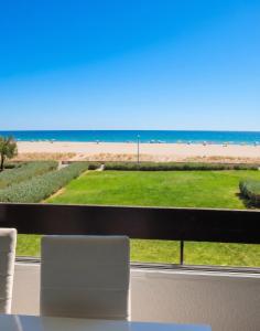 a view of the beach from a room with a table and chairs at Appartement lumineux à Saint-Cyprien 45 m² vue mer in Saint-Cyprien