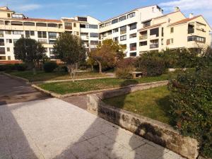 a large apartment building with a park in front of it at Studio charmant à Fréjus avec piscine commune - 30 m² in Fréjus