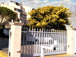a white fence with a tree behind it at Studio charmant à Fréjus avec piscine commune - 30 m² in Fréjus +25 photos