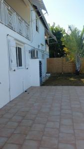 a patio outside of a white house at Appartement confortable avec terrasse à Petit-Canal - 50 m² in Petit-Canal