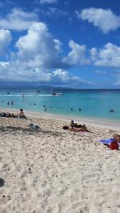 a group of people laying in the sand on a beach at Appartement confortable avec terrasse à Petit-Canal - 50 m² in Petit-Canal