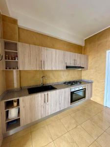 a kitchen with wooden cabinets and a sink at Immeuble Mohamet Mbacké TAÏF in Dakar