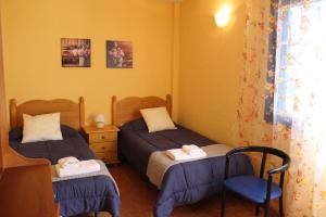 a bedroom with two beds and a chair at Cosy chalet with panoramic views in Icod de los Vinos - 70m² in Icod de los Vinos +20 photos