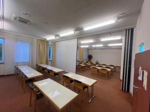 a classroom with tables and chairs in a room at Hansa Apart-Hotel Regensburg in Regensburg