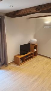 a living room with a television on a table at Le cabanon in Flayosc