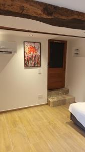 a room with a bed and a television on a wall at Le cabanon in Flayosc