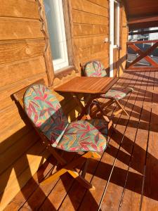 a patio with a table and chairs on a deck at Котедж Amber in Mykulychyn