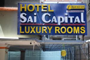 a sign for a hotel saatal capital luxury rooms at Hotel Sai Capital in Vijayawāda