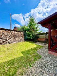 a garden with a bench and a stone wall at Котедж Amber in Mykulychyn