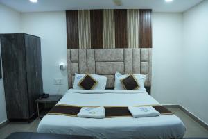 a bedroom with a large bed with two pillows at Hotel Sai Capital in Vijayawāda