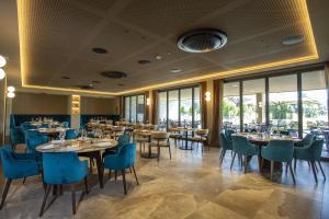 a dining room with tables and chairs and windows at Continental Golf Resort in Verbania