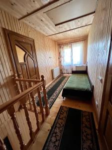 an empty room with a staircase and a green mattress at Котедж Amber in Mykulychyn +15 photos