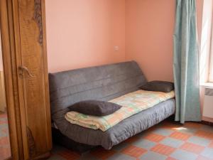 a couch with two pillows on it in a room at Maison accueillante à La Chapelle-aux-Choux avec jardin spacieux 70 m² in La Chapelle-aux-Choux