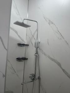 a shower with two shelves in a bathroom with marble walls at Алаша in Qotanqaraghay