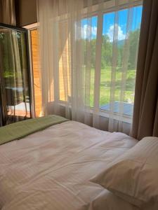a bedroom with a bed and a large window at Алаша in Qotanqaraghay
