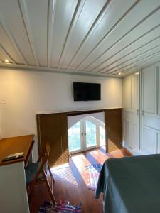 a bedroom with a bed and a tv on the wall at EnjoyPatmos in Skala