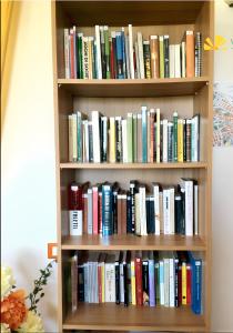 a book shelf filled with lots of books at Charming Studio in Vieste, 25 m², Shared Pool in Vieste